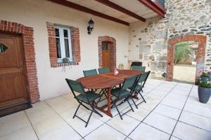 a wooden table and chairs on a patio at Les 3 tilleuls in Bellac