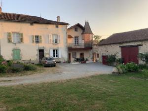 a group of buildings with a car parked in a yard at Les 3 tilleuls in Bellac