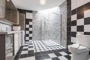 a bathroom with a black and white checkered floor at Kefi Beach & Suites in Ortakent +137 photos
