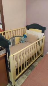 a baby crib with a teddy bear sitting on it at Sea Side View in Dhíkella