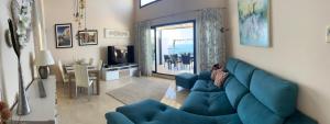 a living room with a blue couch and a table at Best Vistamar Sea View in Torrox Costa