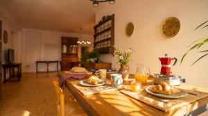 a wooden table with bread and orange juice on it at Roberto Historic House in Gubbio