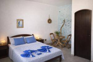 a bedroom with a bed with blue bows on it at Pousada Atelier Aly da Costa in Iguape