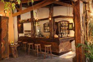 a bar in a room with wooden beams at Pousada Atelier Aly da Costa in Iguape