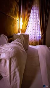 a bedroom with a white bed with a window at Enuana Hotel And Suite in Odobor