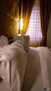 a white bed in a bedroom with a window at Enuana Hotel And Suite in Odobor