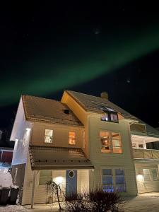 a house with the northern lights in the sky at City Svolvær Apartment in Svolvær