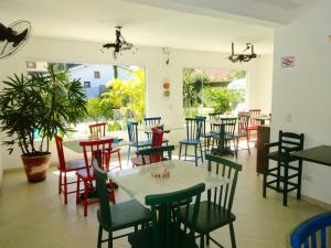 
a dining area with tables, chairs, and tables with umbrellas at Pousada Baía das Conchas in Ubatuba
