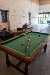 a pool table with two cuesticks on top of it at Studio cosy au calme in Chillac