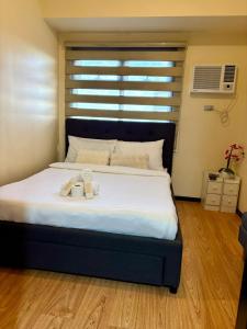 a bedroom with a bed with two mugs on it at Modern Pet Friendly 1br Condo with Balcony near AIRPORT MOA & OKADA Pasay Staycation WFH ready Free Pool Acces Gym and Sauna in Manila +33 photos