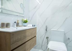 a white bathroom with a sink and a toilet at Bohemian Rhapsody in Kuwait