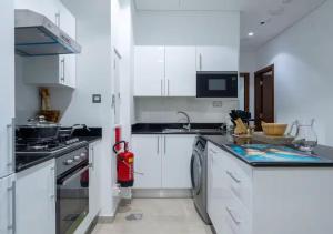 a kitchen with white cabinets and a dishwasher at Bohemian Rhapsody in Kuwait +5 photos