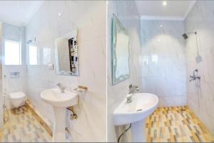 a white bathroom with two sinks and a mirror at Hotel Ashok Palace in Agra +39 photos