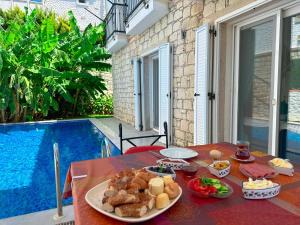 a table with food on it next to a pool at Evalacati-Villa Palma-Central villa with private pool and garden in Çeşme
