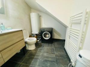 a bathroom with a toilet and a washing machine at Le Petit Francillon in Villebarou