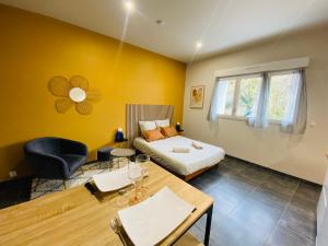 a hotel room with a bed and a desk and a table at Le Petit Francillon in Villebarou