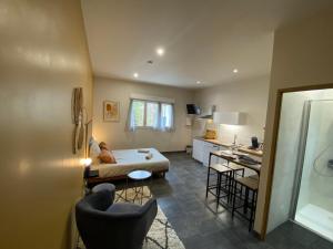 a bedroom with a bed and a kitchen with a sink at Le Petit Francillon in Villebarou