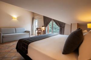sypialnia z dużym łóżkiem i kanapą w obiekcie Hotel Màgic Ski by Nexta w mieście La Massana