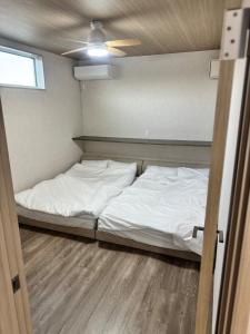 a bedroom with a bed with white sheets and a ceiling at VILLA TSUKUNAMI aoshima in Miyazaki +37 photos