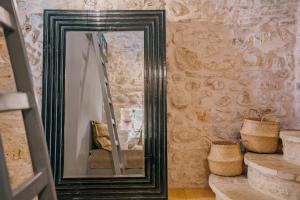 a mirror with a black frame in a room at Alternative Medieval Villa in Kalamoti