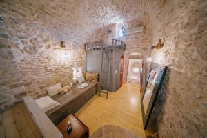 a living room with a couch in a stone wall at Alternative Medieval Villa in Kalamoti