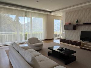 a living room with a white couch and a television at Villa Leom - Mountain Villa with Pool in Antalya in Gedeller