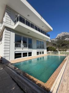 a house with a swimming pool in front of it at Villa Leom - Mountain Villa with Pool in Antalya in Gedeller