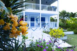 a white house with yellow flowers in the yard at VILLA EDEN Gosier in Le Gosier
