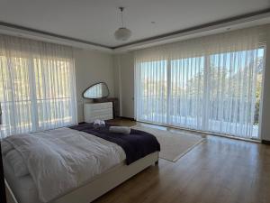 a bedroom with a large bed and large windows at Villa Leom - Mountain Villa with Pool in Antalya in Gedeller +32 photos