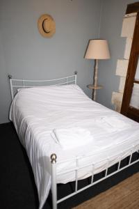 a bed in a bedroom with a white bedspread at Studio cosy au calme in Chillac +14 photos