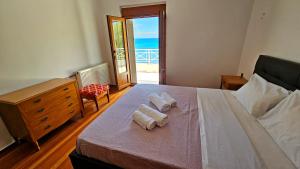 a bedroom with a bed with towels on it at Potokaki Coastal Haven in Potokáki