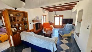 a living room with two chairs and a fireplace at Potokaki Coastal Haven in Potokáki