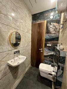 a bathroom with a sink and a toilet and a mirror at Nagpal Farm in Panchkula