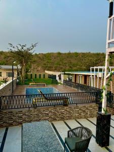a patio with a pool and a chair and a building at Nagpal Farm in Panchkula +31 photos