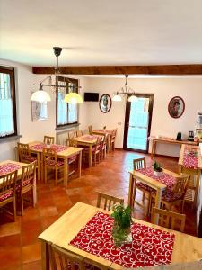 a dining room with tables and chairs and windows at Agri Village Pavia in Certosa di Pavia