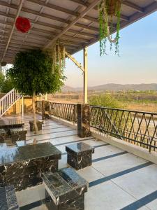 a patio with benches and a balcony with a view at Nagpal Farm in Panchkula