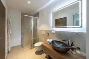 a bathroom with a sink and a toilet and a mirror at Schnitzers Dahoam - Hundefreundlich in Bad Wiessee