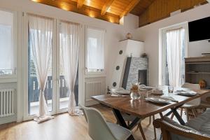 a dining room with a wooden table and chairs at Railway Loft Dimaro I By Immobilux in Monclassico
