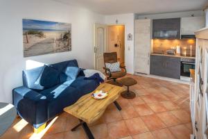 a living room with a blue couch and a table at Fewo Strandallee - Baabe in Baabe