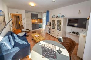a living room with a blue couch and a table at Fewo Strandallee - Baabe in Baabe +23 photos