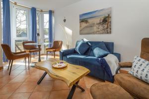 a living room with a blue couch and a table at Fewo Strandallee - Baabe in Baabe