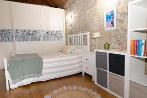 a small bedroom with a bed and a desk at Casa San Son in Pontevedra