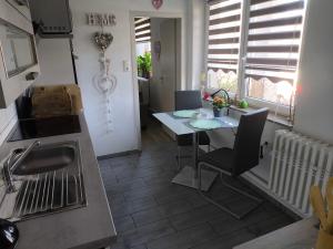 a kitchen with a table and a sink and a table at Ferienwohnung Luka in Kaulsdorf +3 photos