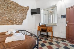 a bedroom with a bed and a desk and a window at Luxar Suites & Apartments in Assemini