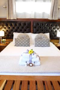 a bedroom with a bed with a suitcase on it at Firwood Lodge in Pretoria