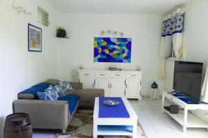 a living room with a couch and a tv at VILLA EDEN Gosier in Le Gosier
