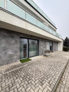 a building with a brick driveway in front of it at ILK Residence 3 in Balatonalmádi