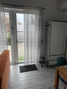 a living room with a couch and a window at ILK Residence 3 in Balatonalmádi