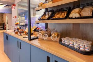 a bakery with a counter with bread and other foods at Font Andorra Hostel by Nexta in La Massana