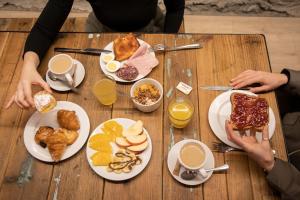 a wooden table with plates of breakfast food on it at Font Andorra Hostel by Nexta in La Massana